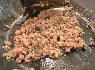step5: 待香味散出時，放入牛絞肉炒散至變色，然後倒入米酒拌勻。