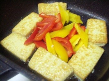 step4: 步驟4在第二面也完成時ˊ將豆腐撥至鍋邊ˊ 然後用餘油炒香蒜末和紅黃椒
