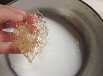 step2: 吉利丁2片剪數段,用冰水泡至軟化,鮮奶加熱到40-50度,將軟化的吉利丁擰乾水份加入鮮奶攪拌至溶解