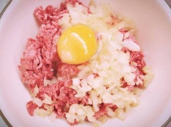 step5: 牛絞肉倒入拌好的麵包粉內並加入炒好的洋蔥，打入一顆蛋且灑上少許鹽及黑胡椒。