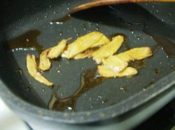 step4: 鍋子加入麻油2大匙中小火加熱ˊ慢慢煸香老薑片ˊ至薑片整個焦香