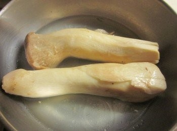 step2: 取一鍋子放入1杯水及一小匙油,將杏鮑菇末端劃十字入鍋煮至滾,撈起切成塊狀