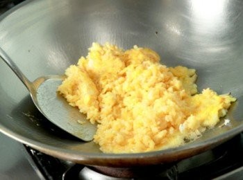 step5: 黃金炒飯的大重點：鍋倒油加熱後放入洋蔥碎炒香，倒入蛋液用鏟子快速拌勻後，倒入沾滿蛋液白飯拌炒至蛋熟後呈金黃色