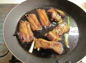 step3: 鍋中放少許油爆香薑片和蔥段,接著放剛剛醃豬肋排的的味全淬釀醬油露.水2杯(量杯)及米酒,一同以小火燉50分鐘(途中要翻),再加入冰糖及1杯水,煮到收汁即可