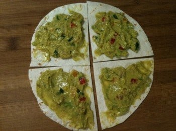 step1: 將墨西哥薄餅皮切成四等份（因為蘋果姊姊的烤箱是一般家用小烤箱，所以要先切餅皮，這樣子烤箱才放得下。如果您家的烤箱是大烤箱的話，就可省略這個步驟囉）後，在墨西哥薄餅皮上塗上蔬果酪梨抹醬。