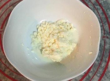 step6: 麵糰第一次發酵約需35-45分鐘，等麵糰發酵時，先進行内餡的準備。 將室溫奶油乳酪加入牛奶和白巧克力粒，用保鮮膜包好後，微波加熱30秒。