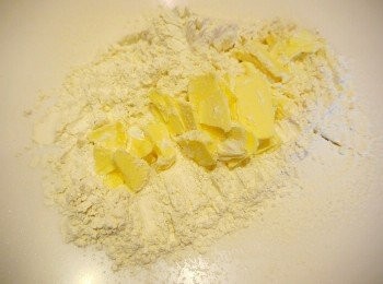 step3: ☞將麵粉過篩在檯面上，在麵粉裡快速將奶油切塊，稍微攪拌後放入蛋黃與冷水，用手快速將材料混好。