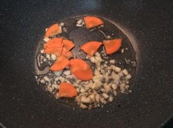 step2: 炒鍋中放適量的油，炒香蒜頭後入紅蘿蔔片略炒。