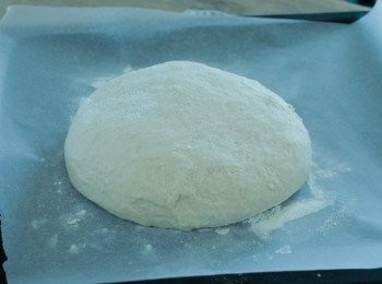step5: 拿出麵糰，用手按壓麵糰，排出空氣，然後塑形，放在鋪有烘焙紙的烤盤上，蓋上保鮮紙，再靜置發酵30分鐘