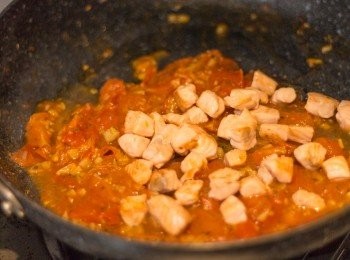 step8: 6-7分鐘後，意粉接近熟的時候，於煮蕃茄之鍋內加入三文魚粒繼續煮，再加入糖﹑黑椒碎及鹽拌勻