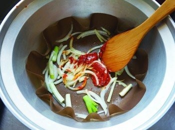 step4: 將所有食材切成適當大小。在外鍋鋪上烘焙紙，倒入香油爆香洋蔥，接著加入韓式辣醬炒出香味