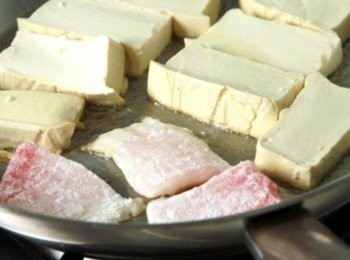 step2: 魚片沾上地瓜粉拍去多餘粉，平底鍋加熱倒入適量油，放入豆腐與魚片將兩面煎香取出。