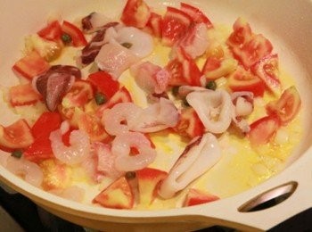 step1: 鍋倒油加熱將洋蔥炒香，接著放入番茄丁和酸豆炒香。再加入海鮮料炒熟