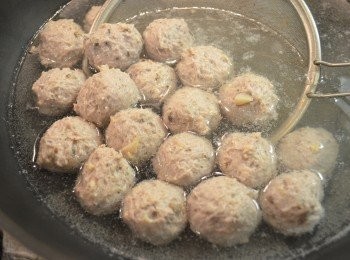 step10: 將冷藏好的豬肉漿取出，用手取適量豬肉漿從虎口擠出圓球狀，再用湯匙刮起放入一鍋約80℃的熱水裡以中小火煮約10分鐘至丸子浮起，即表示熟透。（不要用滾沸的水煮，否則肉丸很易散開。）