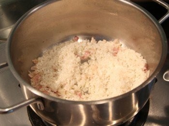 step4: 鍋倒橄欖油轉小火放入洋蔥碎炒出香氣，倒入美國加州玫瑰米用木匙稍微攪拌讓米粒沾滿橄欖油與洋蔥香氣，倒入白酒火轉大些將酒精蒸發後轉小火，倒入雞高湯蓋過米粒，用木匙用稍微輕輕劃圈(不要過度攪拌米粒容易破碎)，待高湯稍微收汁再倒高湯續煮，重覆這方法直到喜歡吃的燉飯口感後，放入蘆筍、花椰菜、培根片、鮮奶油、鹽、起司粉拌勻即可盛盤，擺上雞肉片、培根絲即完成。