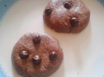 step2: 加入牛奶及溶化的奶油拌勻，會形成一個粉糰。做成圓塊，加巧克力碎片，放在碟上，放入微波爐最大火力先焗30秒，停一下，再焗15秒，停一下，再焗10秒。如曲奇表面已乾便可，中間應該是軟軟的，如未熟，可再焗10秒