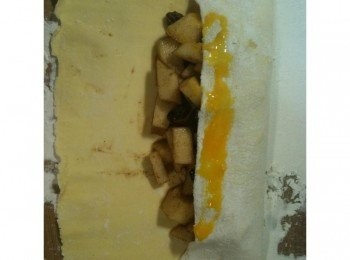 step6: 將捲皮的一邊往中間折過來，用湯匙挖取蛋液，塗在捲皮接合處。