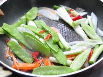 step2: 熱鍋後，將準備好的豌豆夾、大蒜段、蔥段、紅蘿蔔絲、辣椒絲下鍋拌炒