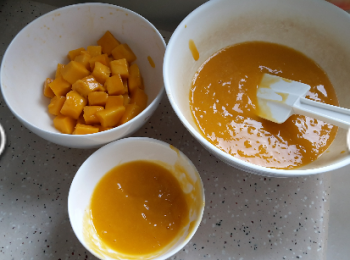 step3: 芒果蓉分開兩碗盛載，一碗50gm做流心饀，另一碗300gm做旦糕體。 用保鮮紙將50gm芒果蓉包好，放在平碟上，放入冰格。