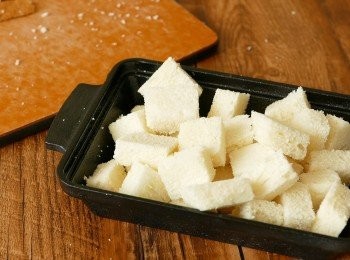 step2: 把方包切成 1 – 2 吋邊長方粒，可選擇留下或去掉包皮，如包皮太硬建議去掉較好。把麵包粒放於焗盤內備用。