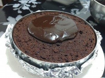 step8: 封上另一片蛋糕, 用手輕輕按壓,  再上面倒上適量朱古力醬，輕搖蛋糕令朱古力醬均勻地流在蛋糕表面 或 用長抹刀從右至左抹平（最好一次過抹好， 否則蛋糕面不夠光滑）