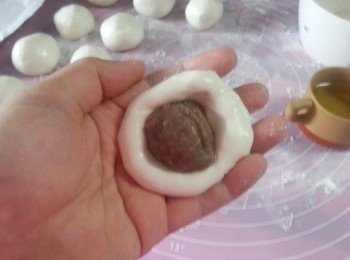 step11: 用一個碗裝少許水(如包餡時,粉太乾濕手用),取一粒粉按成一個手指長度的圓型,包入一粒紅豆餡搓成圓型,
放在碟中蓋上濕布(預防乾身)