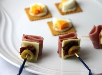 step6: 取一牙籤，串上橄欖片、風乾蕃茄、起司片、火腿片後，插上水煮蛋，加上茴香葉裝飾