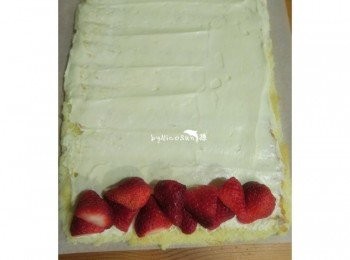 step7: 烤好放涼.撕去烘培紙.抹上一層鮮奶油在鋪上草莓