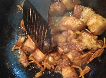 step4: 燒熱2茶匙油, 爆香薑片,下五花腩爆炒,正至油份慢慢滲出, 下一湯匙黃糖, 慢火炒至五花腩變成淺焦糖色,將魷魚乾回鑊。