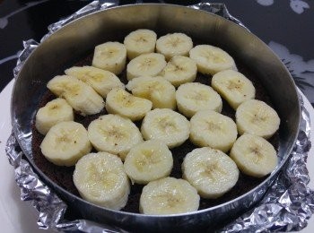 step7: 將蛋糕模洗淨抹乾包上錫紙, 將一片蛋糕放模內， 舖上香蕉片(1/4吋厚)， 淋上一層朱古力醬， 要剛蓋著香蕉