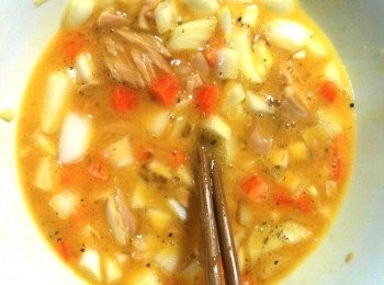 step4: 調製蛋液：取出一個碗，加入蛋，打成蛋液，放入步驟3的洋葱碎和紅蘿蔔碎，放入鮪魚罐頭，灑上黑胡椒、白胡椒和義大利香料，用筷子攪拌均勻。