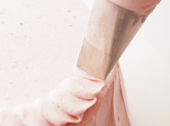 step9: 使用玫瑰擠花嘴，在蛋糕的外緣畫出螺旋形
將奶油霜擠成皺褶狀