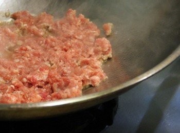 step2: 絞肉拌入米酒、醬油醃約10分鐘。鍋加熱倒入少許油，放入蒜末炒出香氣倒入絞肉炒香。