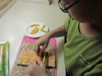 step2: 竹簾上方鋪上保鮮膜,依序放上海苔→吐司→抺上鮮蝦沙拉(可買現成的鮮蝦沙拉或蝦肉切碎拌入沙拉醬) 放小黃瓜條及芒果條→擠上沙拉醬