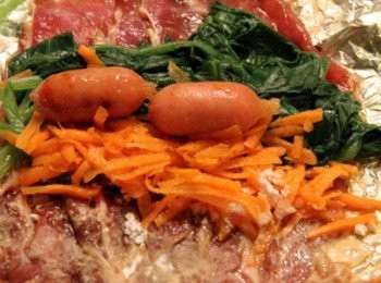 step3: 取3~4片肉片放在鋁箔紙上(視大小而定)交互相疊排好，重疊處可以灑些麵粉當黏劑，依序放入菠菜、紅蘿蔔、2個小香腸，捲起鋁箔紙將肉捲起，再用手將肉卷捏實