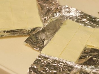 step9: 等白巧克力稍微凝固、仍保有一點軟度時，利用刀子將其切成16等份的薄片(4cmx4cm大小)，移去鋁箔紙。