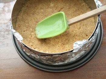 step2: 將消化餅放入塑膠袋中，用桿麵棍壓成粉狀；吉利丁泡飲用水備用。無鹽奶油置於室溫軟化後，放入裝著消化餅的塑膠袋中充份拌勻，將餅屑紮實地、平均地壓附在慕絲圈底部後，放入冰箱約30分鐘定型