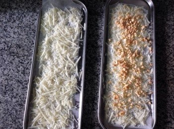 step1: 先用牛油紙鋪在淺口不銹鋼長盤上，平均灑上芝士碎交疊平埔在焗盤上（喜歡可以再灑上少許果仁碎）