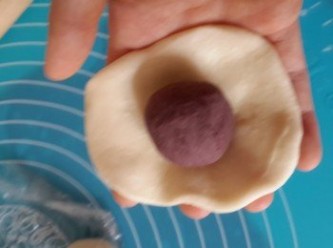 step7: 將紅豆蓉於麵團中間，食指和拇指褶起，收口，再滾圖，收口向下放於牛油紙上