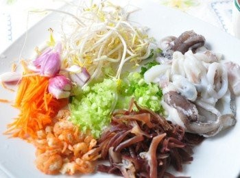 step2: 備料如圖:先將真空包裝新鮮花枝放入水中解凍後，處理內臟物取出清洗，切成塊狀；另外紅蘿蔔、木耳切細絲；青蔥與芹菜切末；其他乾蝦仁、綠豆芽洗淨備用