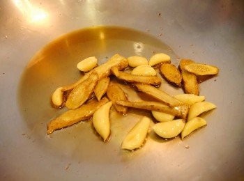 step2: *熱油鍋，入麻油小火煸香薑片。至薑有乾扁狀以及香氣出~再加入蒜頭粒續炒~