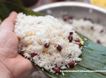 step2: 9.先將<span class="group_3">調味料</span>加入糯米中撈均，再加入紅豆拌勻。
10.攞起兩塊葉，打十字，屈起摺成一個「兜」。
11.先放入糯米，再放一層綠豆。
12.跟著放入一粒咸蛋黃，一件腩肉及半粒瑤柱。
13.再放一層綠豆，最後放一層糯米。