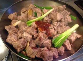 step3: 熱鍋爆香蔥、薑，放入作法2牛肉及豆瓣醬翻炒均勻。