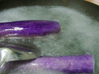 step2: 鍋內放入足量的水煮滾ˊ加入油1大匙ˊ鹽1茶匙ˊ 如果鍋夠大就將茄子整根擺入ˊ如果鍋子容量不夠ˊ就將茄子對半切ˊ (擺入同時要讓整根茄子浸泡於沸水中ˊ這是保持茄子美麗顏色的小訣竅喔)