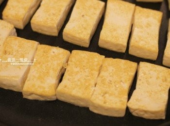 step2: 不沾平底鍋中抹上少少一層油，中火燒熱，放入切塊、瀝去多於水份的豆腐，兩面煎至金黃後盛起。