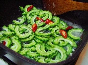 step5: 接著加入苦瓜和辣椒略為拌炒ˊ並加入酌量的水拌炒至喜好程度