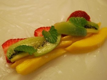 step2: 將米紙鋪在乾淨檯面上，於米紙中央放上草莓片、芒果、奇異果，以及三小片薄荷葉