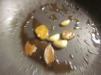 step3: 鍋中放黑麻油,以小火爆香薑片及大蒜至微微乾扁