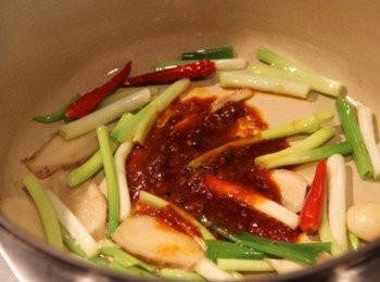 step2: 鑄鐵鍋倒入橄欖油，放入蔥、薑、蒜、洋蔥炒香，倒入豆瓣醬、花椒辣醬炒香。