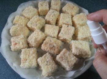 step7: 用牛油紙舖上光波爐有洞之蒸碟上,排好豆腐粒(因蒸碟有洞熱風會吹得較均勻,而用牛油紙就不會痴底),入爐前如有噴油就噴上油於豆腐底及面